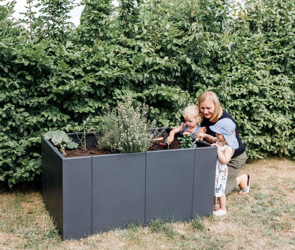 Hochbeet Monterosso wird bepflanzt von einer Mama mit ihren Kindern | Pulverbeschichtet anthrazit