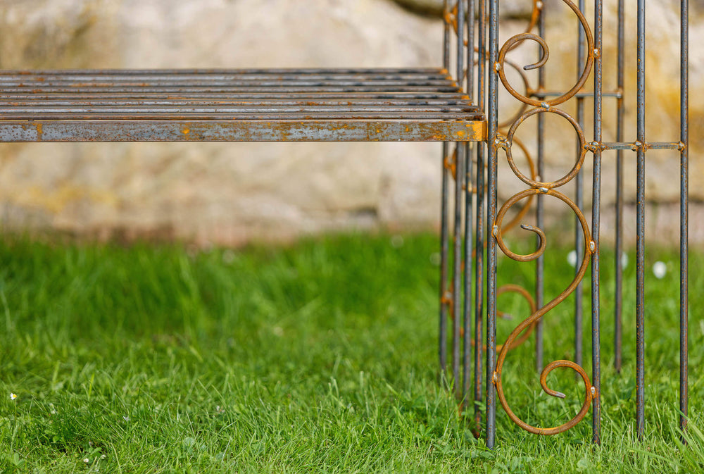 Rosenbogen Calabria mit Bank in unbeschichtet aus der Nähe in einem Garten